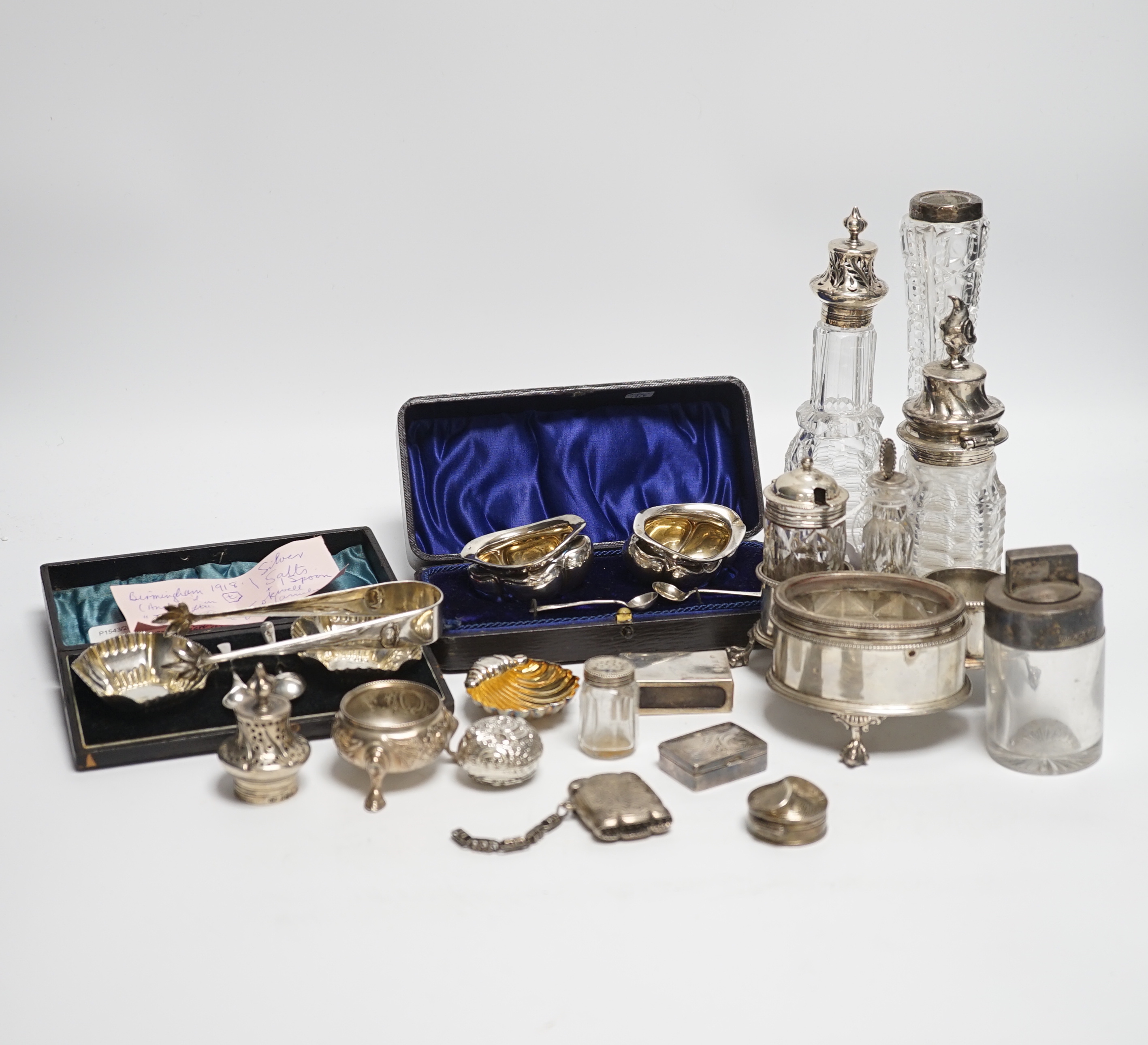 Sundry small silver including a Victorian silver cruet stand, London, 1858 (lacking one bottle), two salts, a vesta case, pill boxes, pair of sugar tongs, two cased pairs of salts with spoons, five mounted glass bottles,